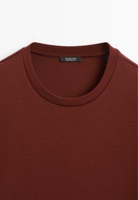 Burgundské tričko s kulatým výstřihem vyrobené z měkké bavlněné tkaniny, s hladkým povrchem a štítkem s názvem značky "Massimo Dutti."