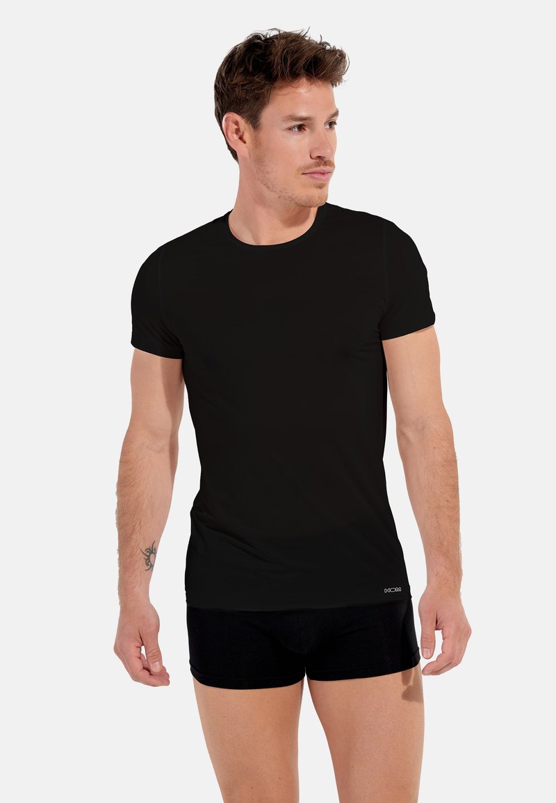 Czarna, krótko rękawowa koszulka z miękkiego, elastycznego materiału. Posiada okrągły dekolt oraz dopasowany fason.