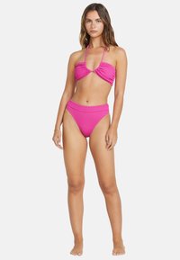 Žiarivý ružový bikini set, ktorý obsahuje textúrovaný halterneck top s detailom twist a vysoký spodný diel, oboje v rebrovanom prevedení.