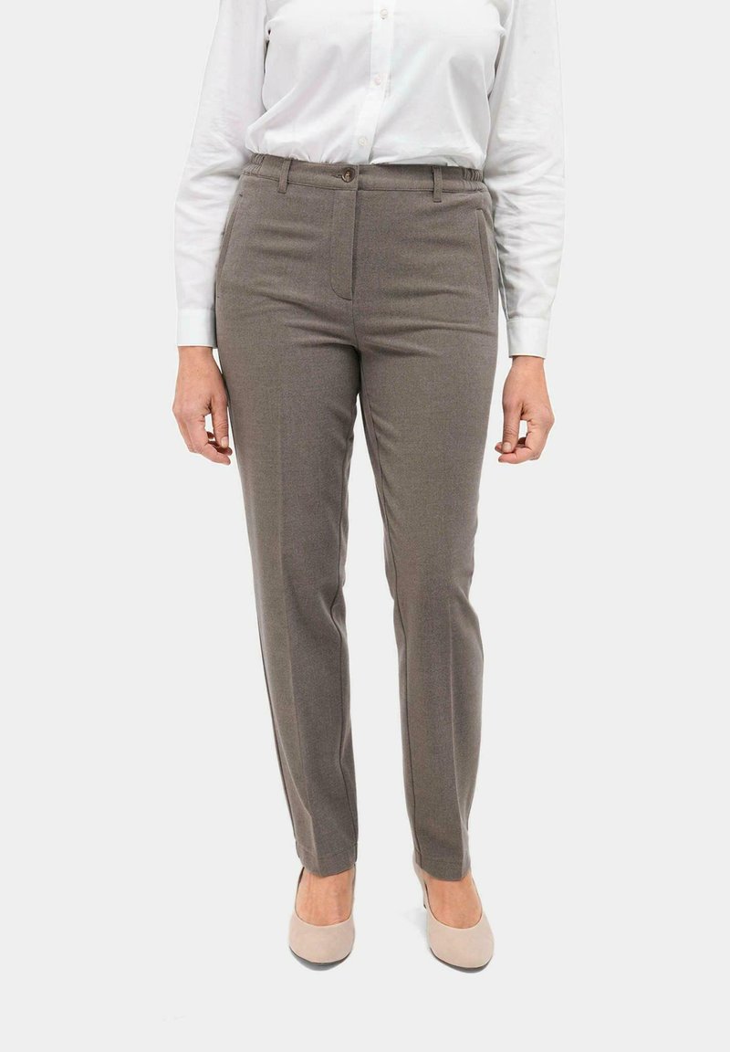 Tapered bruine broek van een gestructureerde stof, met een voorzak, riemlussen en een knoopsluiting, gecombineerd met een wit shirt.