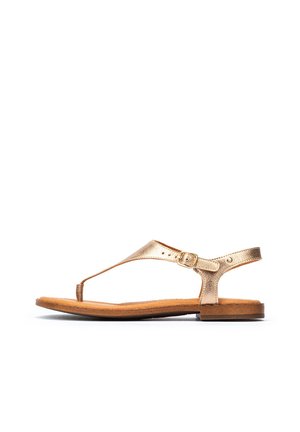 Sandale en cuir métallique doré avec séparateur de orteils, bride de cheville ajustable et semelle plate marron, présentant un design minimaliste et une texture lisse.