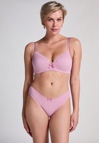 Helles rosa geripptes Lingerie-Set bestehend aus einem Bralette mit Spitze und Schleifenakzenten, kombiniert mit passenden Panties mit Spitzenbesatz.