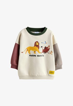 Krēmas krāsas džemperis ar zaļām, burgundijas un pelēkām piedurknēm. Uz tā ir lauvas attēls un rakstzīmes ar tekstu "HAKUNA MATATA". Izgatavots no kokvilnas maisījuma ar ribotu apkakli.