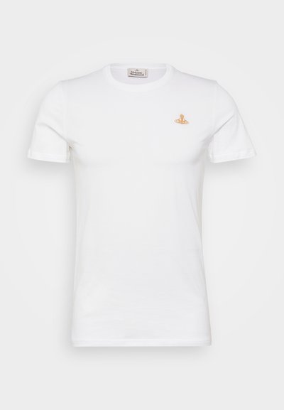 Balta medvilnės marškinėliai trumpomis rankovėmis. Ant kairio krūtinės šono yra nedidelis auksinis logotipas. Klasikinio apvalaus kaklo dizainas. Lygi tekstūra.