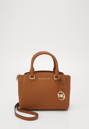 Sac à main en cuir marron Michael Kors avec double poignée, une bandoulière amovible et un charm avec logo MK doré suspendu sur le côté.