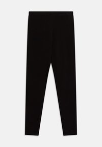 Zwarte leggings van een zachte, rekbare stof. Met een brede tailleband en een slank, taps toelopend ontwerp van de benen. Geen zichtbare patronen of accenten.