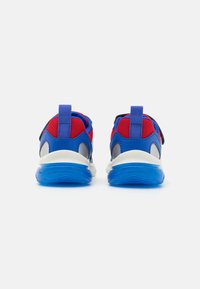 Chaussures de sport bleues et rouges avec une tige en mesh, un soutien de cheville rembourré et une semelle bleue translucide avec un motif texturé.