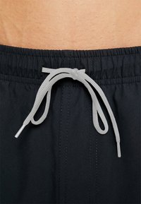 Fekete úszónadrág, texturált felülettel, elasztikus derékkal és világosszürke állítható zsinórral.