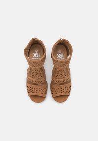 Brązowe sandały z wycięciem i otwartym noskiem, z teksturowaną syntetyczną cholewką, geometrycznymi wzorami oraz zamkiem błyskawicznym z tyłu. Rozmiar 37.