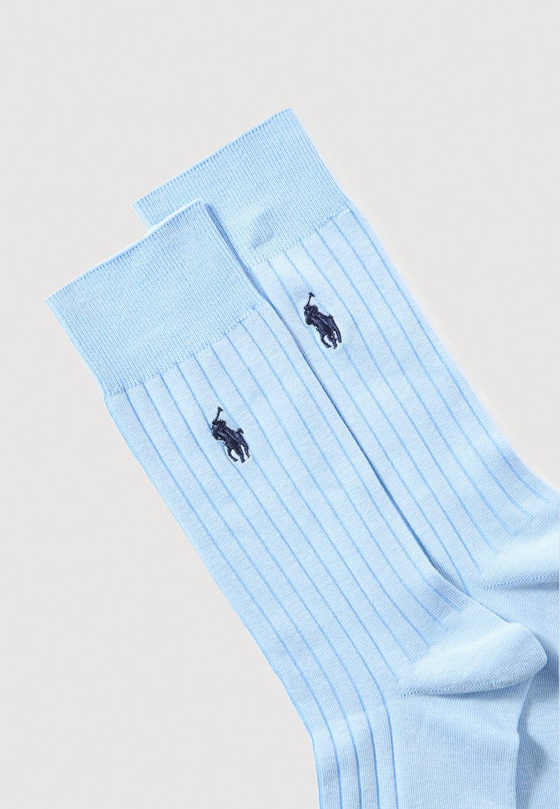 Light blue ribbed socks with a solid cuff, featuring a small dark blue logo. Made of soft material, suitable for casual wear.