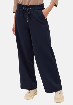 Pantalons de jogging large en navy avec une taille élastique et un cordon de serrage. Comprend des poches latérales et une texture lisse. Coupe décontractée.
