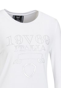 Witte lange mouw t-shirt met een ronde hals, versierd met zilveren rhinestones die de tekst "19V69 ITALIA" en een schildontwerp vormen.