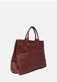 Leren handtas in diep rood met twee korte handvatten, een getextureerde patch met gouden beslag en een strak, gestructureerd silhouet.