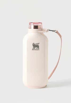 Crème kleurige geïsoleerde Stanley-fles met roze deksel en afneembare roze draagriem op een witte achtergrond.