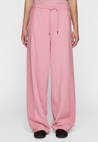 Roze wijde sweatpants met een textuur op het oppervlak en een elastische tailleband. Inclusief zijzakken en een trekkoord voor aanpassing.