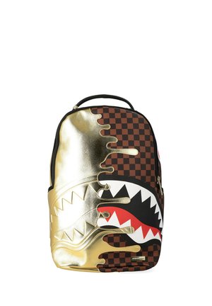 Zaino con motivo a scacchiera marrone e design con gocce di vernice metallica dorata con una grande bocca di squalo con denti rossi e bianchi.