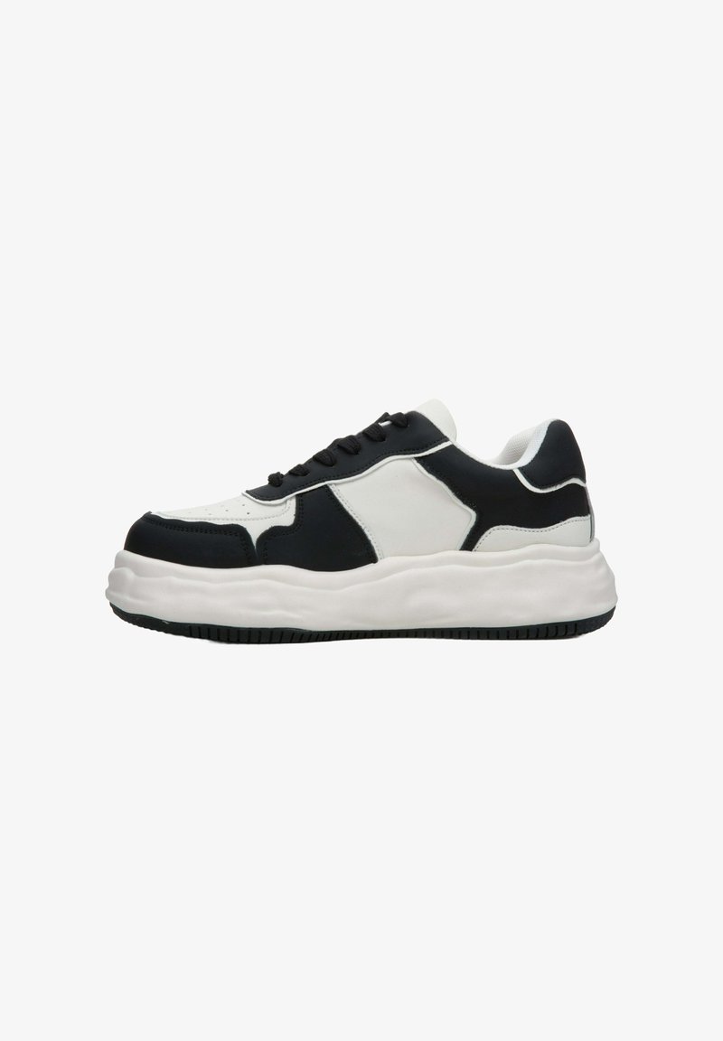 Czarno-białe trampki z grubą podeszwą, wykonane z mieszanki gładkich i teksturowanych materiałów, z zapięciem na sznurówki i wyściółką w okolicy kostki.