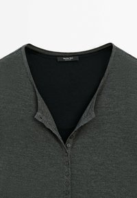 Dark gray henley shirt with a slightly textured fabric, featuring a button-down placket and a V-neck collar. Brand label visible inside.