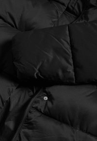 Černá péřová bunda s prošívaným designem, která má hladký povrch, kovové patentky a viditelný zip na jedné straně.