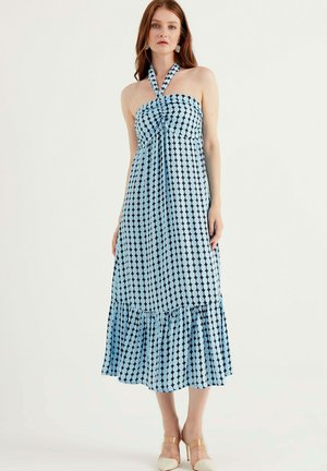 Sukienka maxi w jasnoniebieskim kolorze w ciemnoniebieskie kropki, na szyję, zmarszczona góra i falbaniasty dół. Gładka faktura materiału.