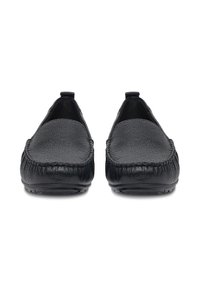 Czarne skórzane mokasyny z fakturowaną powierzchnią, płaską podeszwą i detalem stębnowania wzdłuż krawędzi. Widok z przodu podkreśla prostą formę i design.