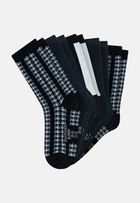 Zestaw siedmiu skarpetek w kolorze czarnym i szarym, z różnorodnymi wzorami, w tym paski i kropki. Wykonane z miękkiego materiału dla wygody.
