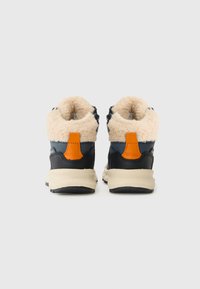 Navy en tan hoge schoenen met een beige nepbont kraag, een oranje accent op de hiel en een gestructureerde rubberen zool, met een gestructureerd ontwerp.
