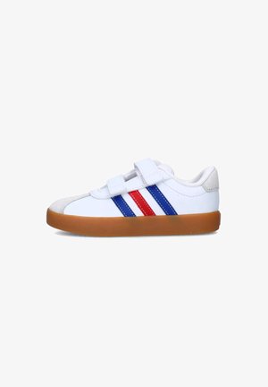 Sneaker bianco con due bande in velcro, strisce laterali rosse e blu, e una suola in gomma marrone chiaro. Pelle liscia con dettagli testurizzati.
