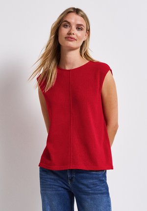 Röd ärmlös topp i texturerad tyg, med rund halsringning och rak skärning. Matcher med blå denimjeans.