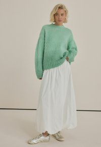 Mint green fuzzy sweater, white flowy skirt, and silver sneakers. Soft texture, loose fit, ribbed cuffs, and wide waistband detail.