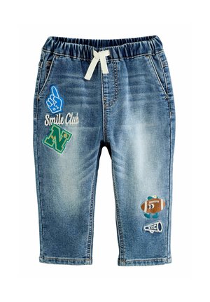 Pantalon en denim bleu pour tout-petit avec taille élastique et cordon blanc, décoré de patchs comprenant un doigt en mousse, la lettre N, un ballon de football et un mégaphone.