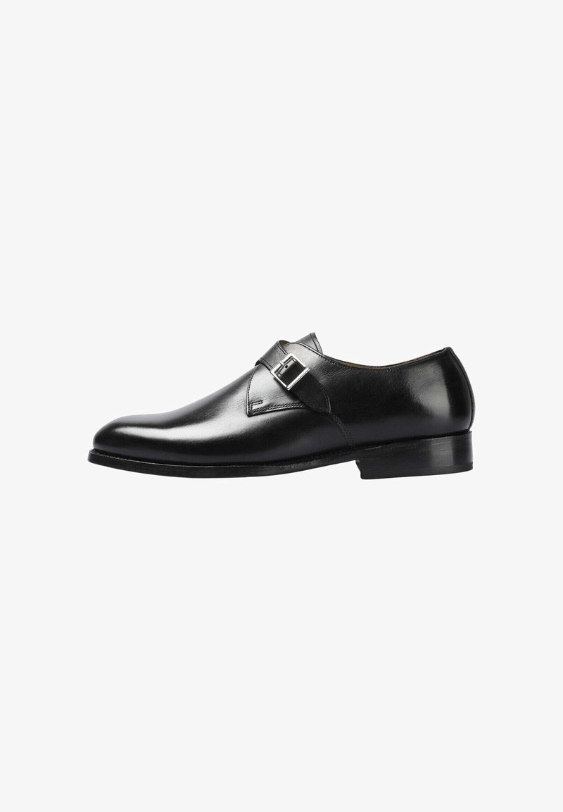 Zapato de vestir de cuero negro con punta redondeada, correa con hebilla única, textura suave y tacón bajo apilado, con detalles de costuras discretas.
