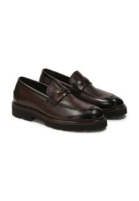 Mocasines de cuero marrón con un acabado suave, punta redonda y costuras decorativas. Presenta una suela de goma negra texturizada y baja.