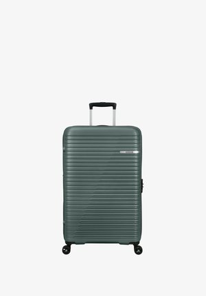 Hartschalenkoffer in Dunkelgrün mit linearer Rillenstruktur. Verfügt über einen ausziehbaren Griff und vier drehbare Rollen für einfache Mobilität.