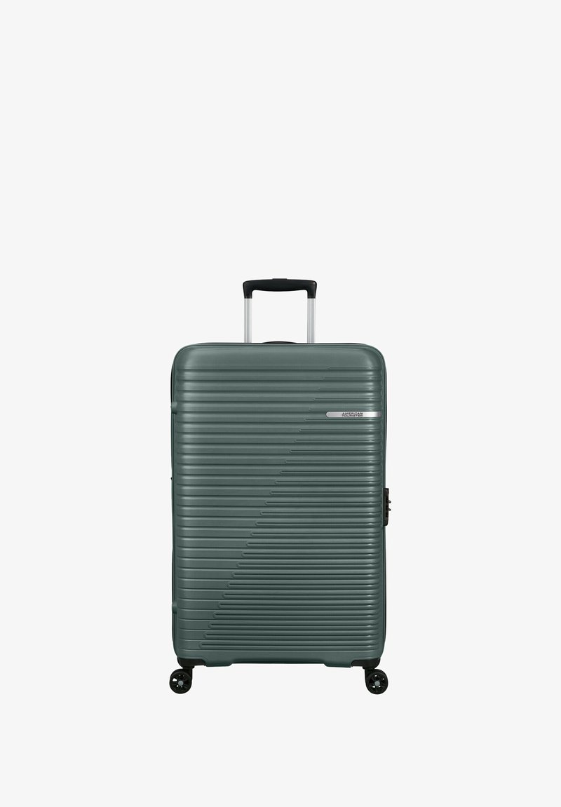 Valise rigide de couleur vert foncé avec une texture à rayures linéaires. Elle est dotée d'une poignée rétractable et de quatre roulettes pivotantes pour une mobilité aisée.