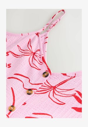 Material texturat roz cu imprimeu floral roșu, bretele subțiri ajustabile și trei butoane maro dispuse pe verticală pe fața unei piese vestimentare fără mâneci.