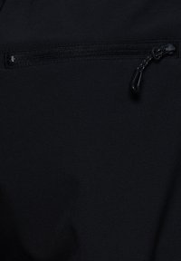 Zwarte stof met een horizontale gesloten rits met een zwart trekkoord met reflecterende stiksels.