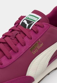 PUMA Easy Rider tenisice s gornjim dijelom od ljubičastog nubuka, bijelim kožnim detaljima, teksturiranim vezicama i zlatnim logotipom. Klasičan niskoproljetni dizajn.