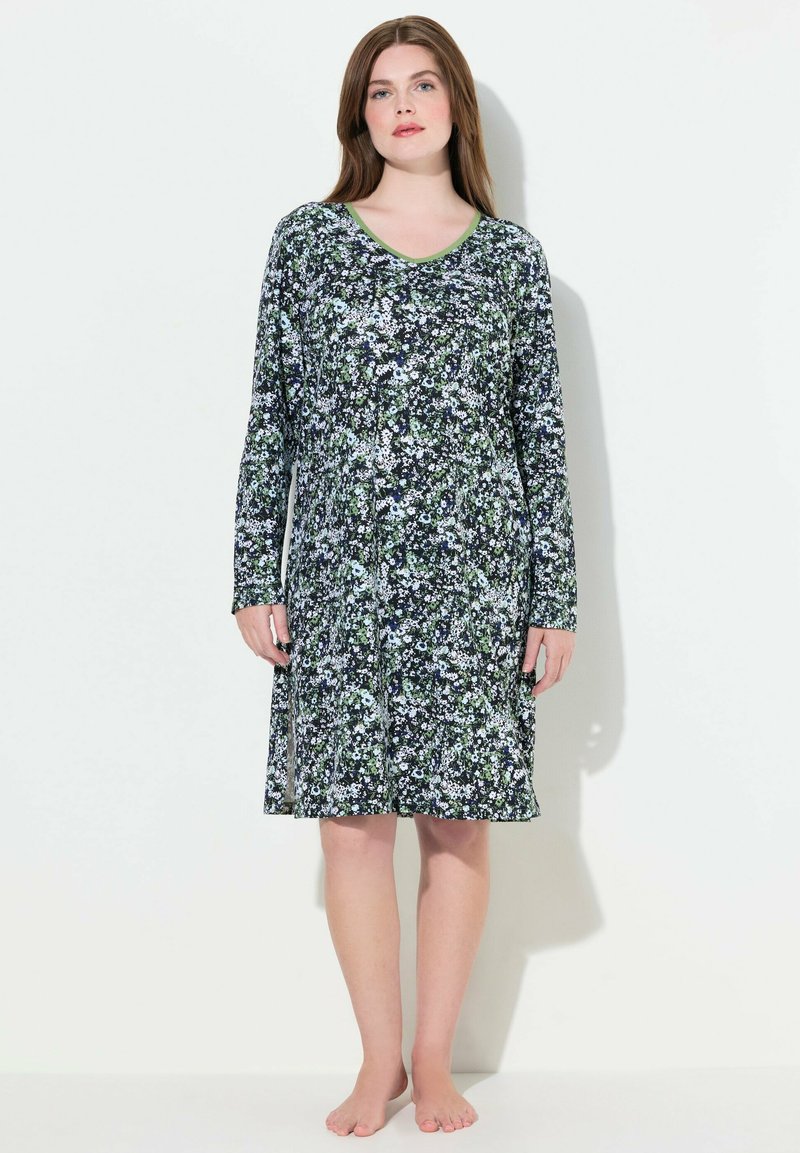 Camicia da notte floreale con maniche lunghe, realizzata in tessuto leggero. Presenta uno sfondo scuro con motivi floreali verdi e bianchi e un collo rotondo.