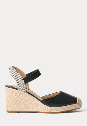 Sort espadrille kilehæl sandal med lukket tå, flettet jute plateau og elastisk ankrem med beige og sort mønstret stof på hælen.