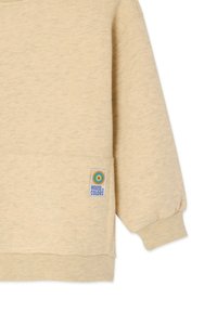 Sweat-shirt beige à texture douce, avec un col rond et une petite poche ornée d'un logo coloré "House of Colors".