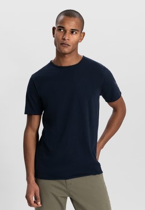 T-shirt a maniche corte blu navy realizzato in tessuto morbido, presenta un collo a giro e una vestibilità rilassata. Nessun motivo o logo visibile.