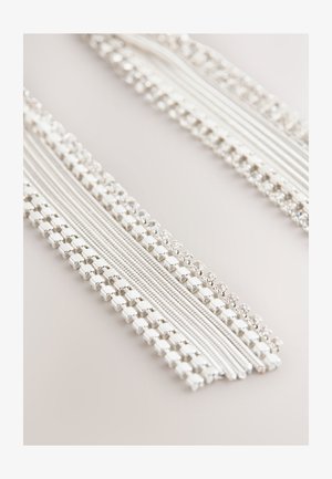 White fabric trim featuring alternating strands of smooth textures and beaded accents, with metallic square and round details throughout.
