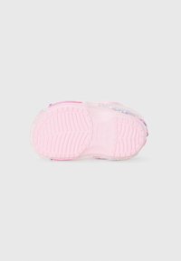 Pink rubber shoe with a textured sole; transparent glittery accents and a smooth upper surface. Rounded shape, with raised lug pattern on the sole.
