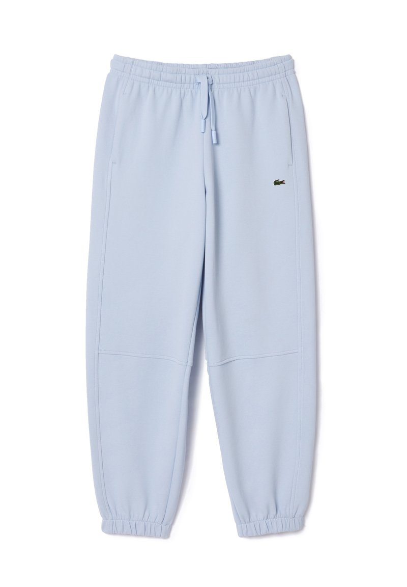 Pantalones de chándal de color azul claro, hechos de una tela suave. Cuentan con una cintura elástica, dobladillos acampanados, dos bolsillos laterales y un pequeño logotipo verde en la parte frontal.