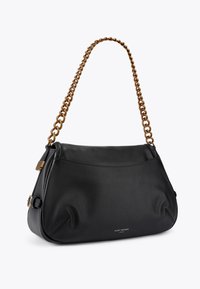 Borsa a spalla in pelle nera con una forma morbida, tracolla in catena dorata e un logo discreto sul fronte. Texture liscia, design minimalista.