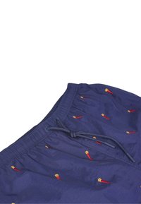 Costumi da bagno blu navy realizzati in un tessuto leggero, con ricami a forma di peperoncini rossi in tutto il capo e una vita elastica con coulisse.