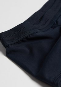 Cintura elástica azul marino con agarre texturizado, cuerpo de tela suave y costuras mínimas, diseñado para comodidad y flexibilidad.