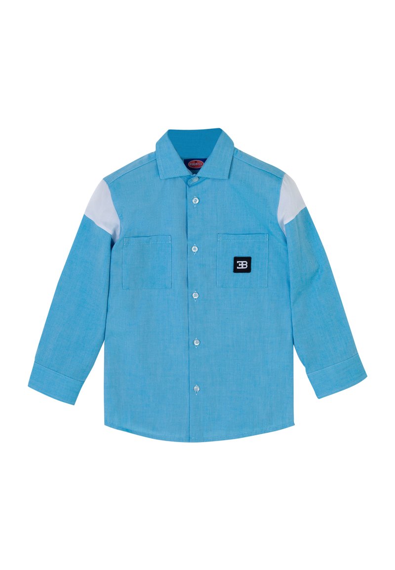 Camicia azzurra con bottoni e maniche lunghe, dotata di due tasche frontali, spalle bianche e una toppa nera con logo sulla tasca sinistra.