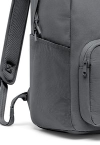 Grå ryggsäck med ett texturerat yttre, dragkedjefickor och ett vadderat axelband för komfort. Hållbart material med en elegant design.